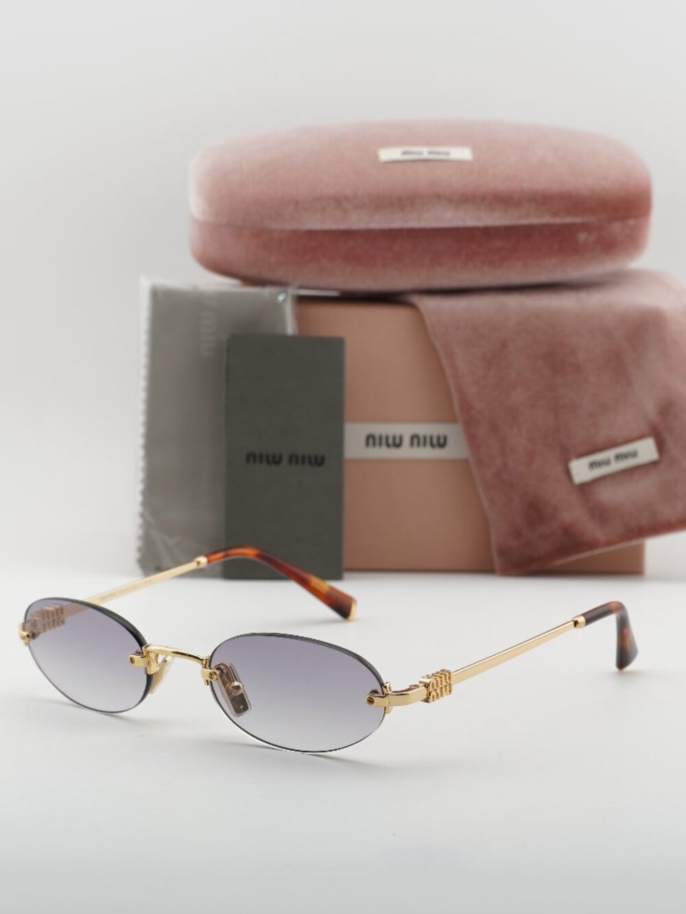 Miu Miu MUA54S 5AK04O Oval Rimless Sunglasses – Gold / Clear to Grey